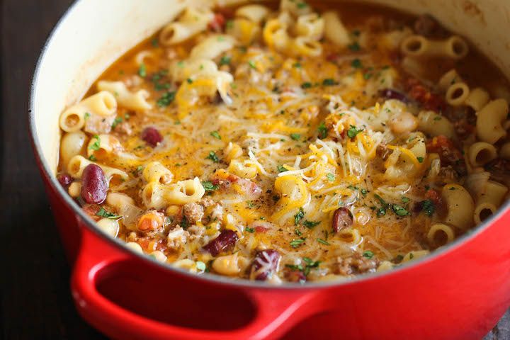 a red pot filled with macaroni and cheese soup