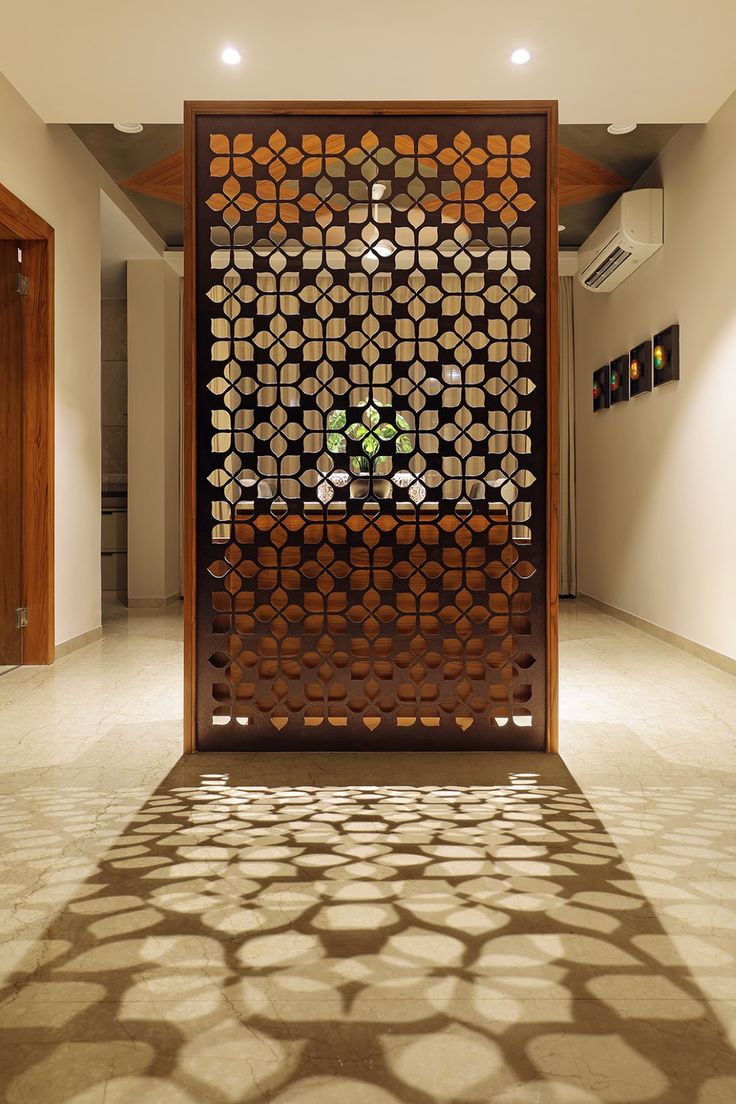 a room divider in the middle of a floor with circles on it and a potted plant behind it