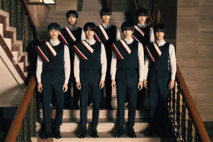 a group of young men standing next to each other on top of a stair case