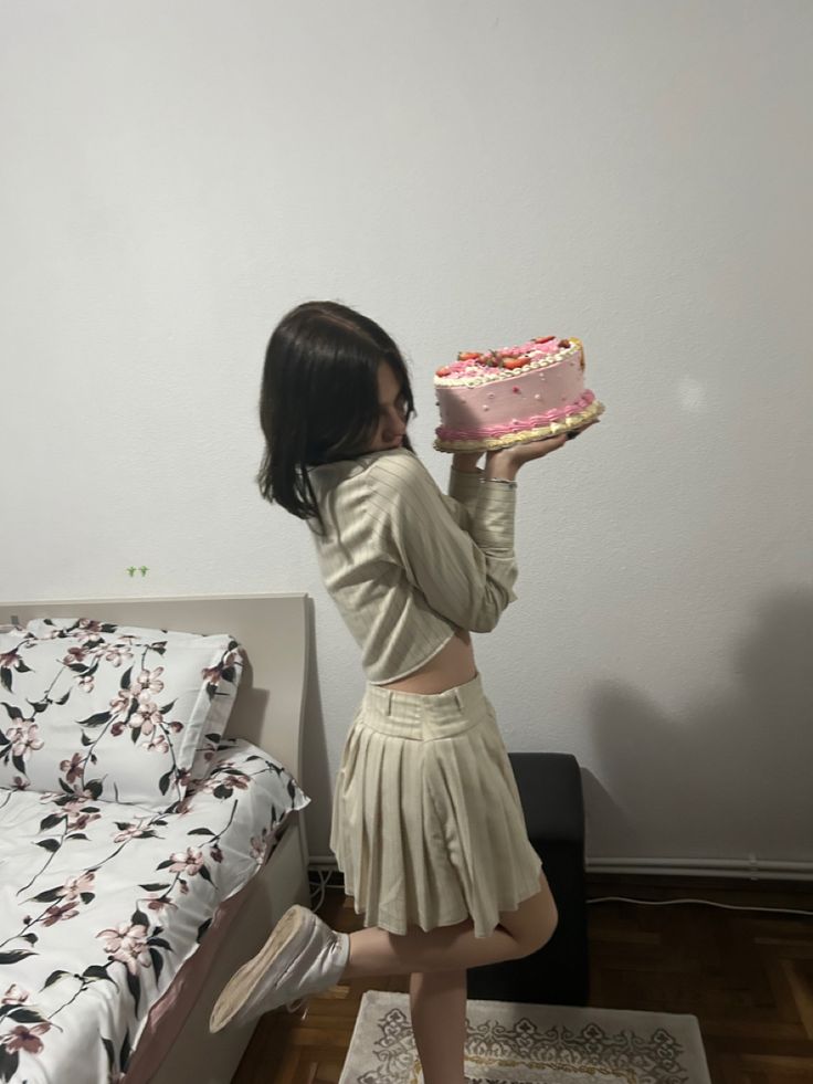 a girl in a short skirt is holding a piece of cake and looking at it