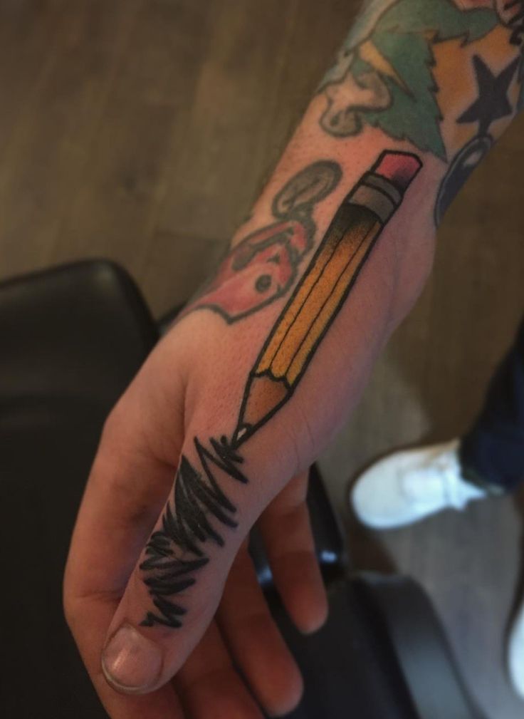 a person's hand with a pencil tattoo on it