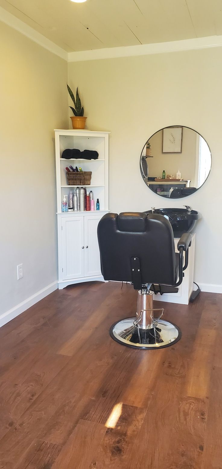 a chair that is sitting in the middle of a room with a mirror on it