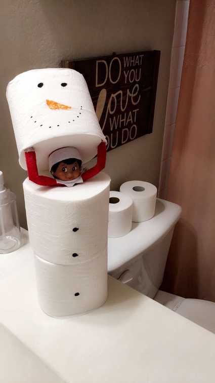 a toilet paper snowman is sitting on top of the toilet