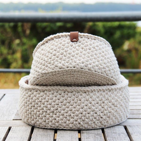 a white knitted hat sitting on top of a wooden table next to a window