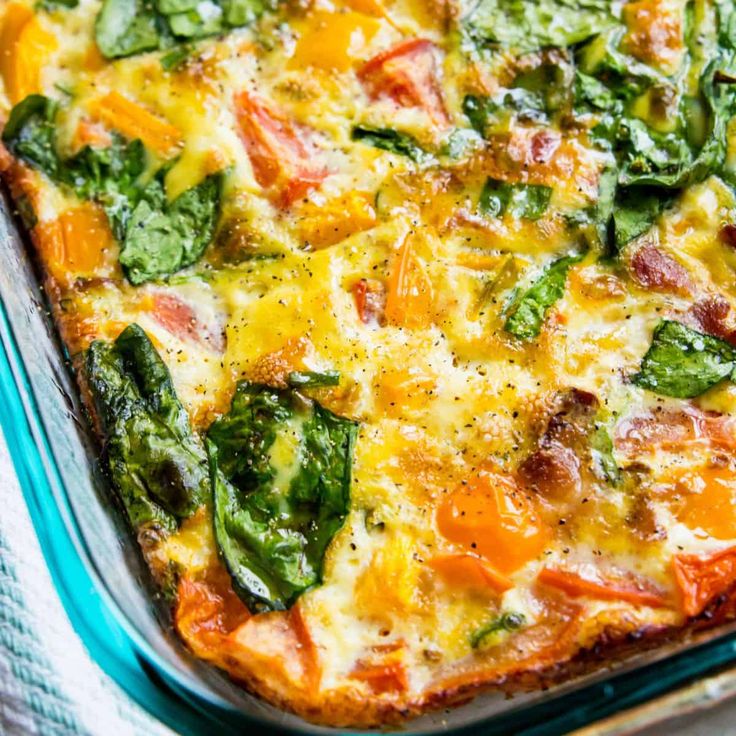 a casserole dish with spinach, ham and cheese in it on a blue cloth