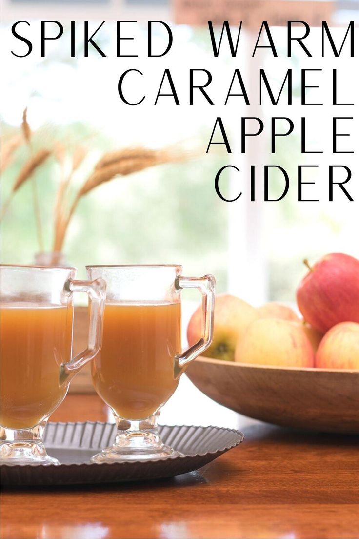 two glasses of apple cider on a table with apples in the background and text overlay