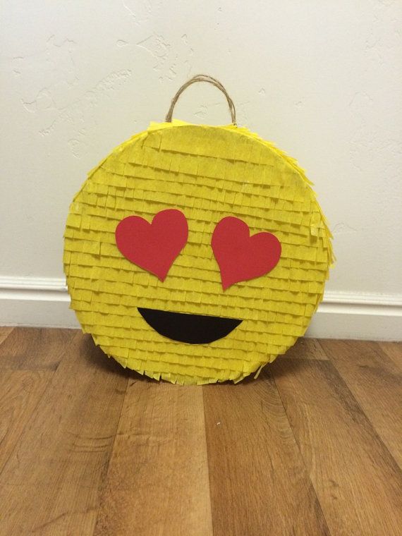 a yellow basket with red hearts on it sitting on the floor next to a wall