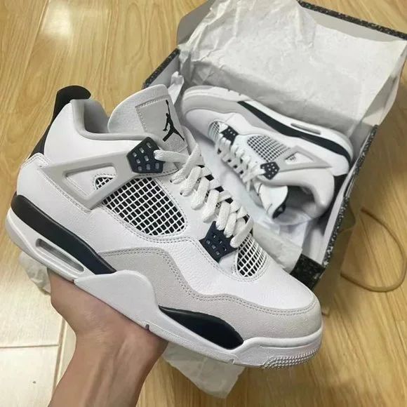 someone is holding up their white and black nike air jordans in a shoe box