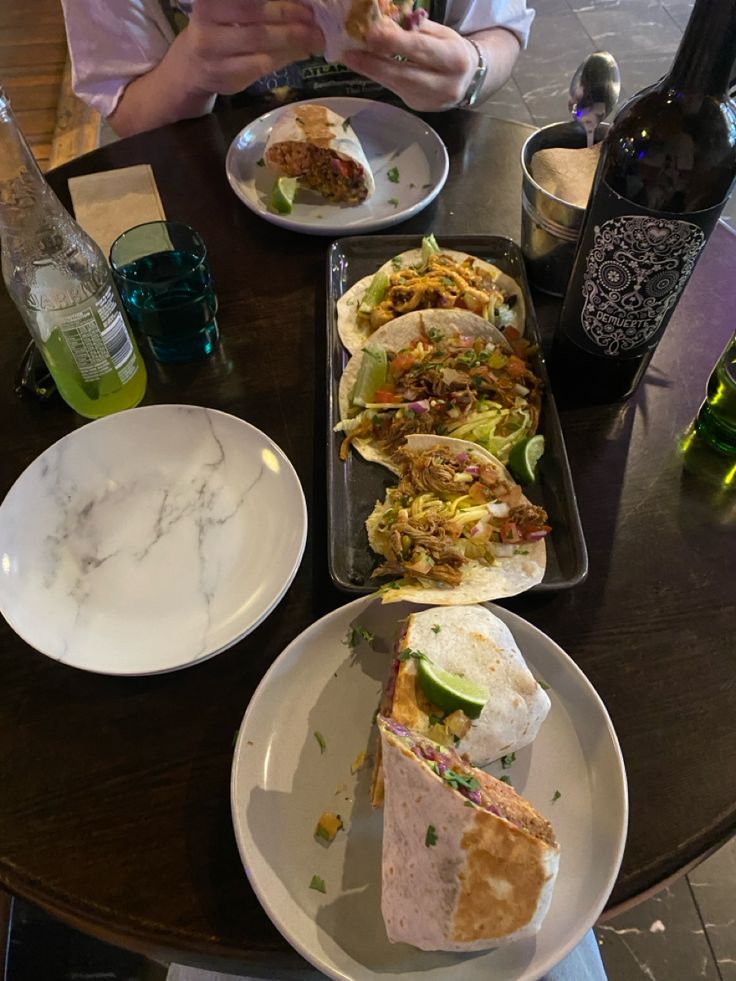 a person sitting at a table with plates of food