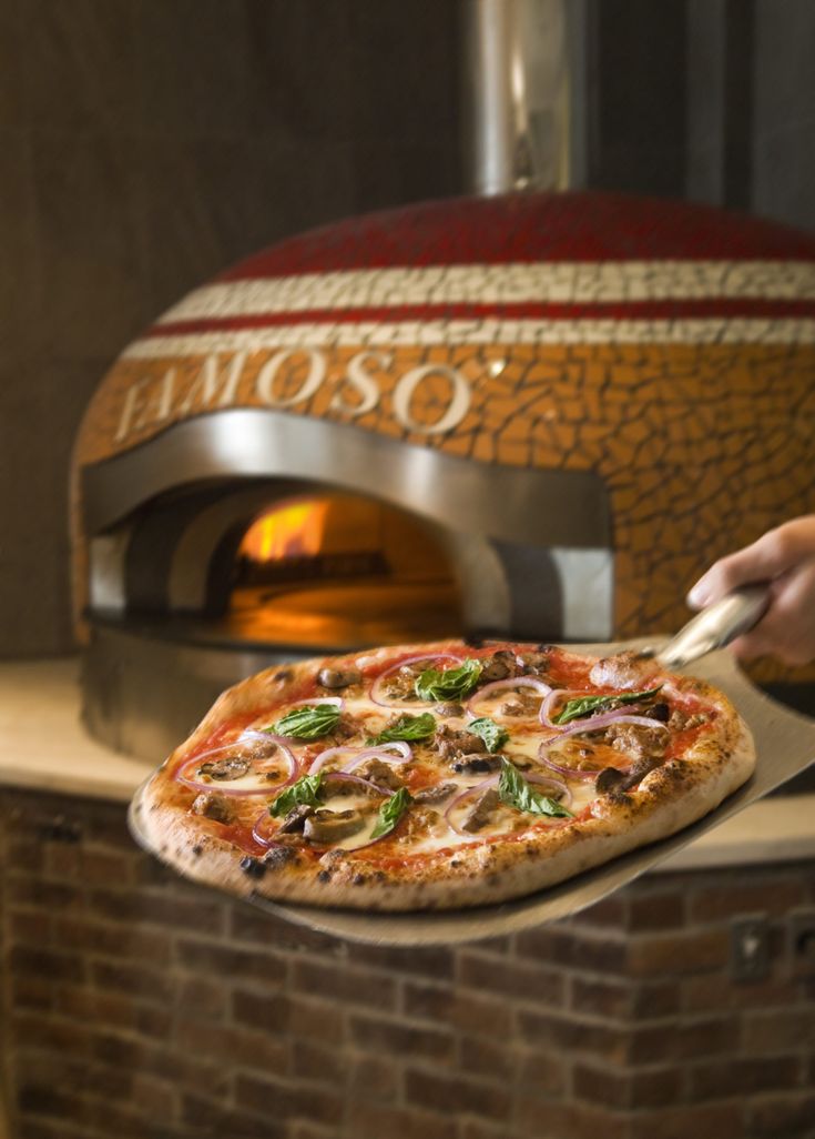 a pizza is being cooked in front of an oven