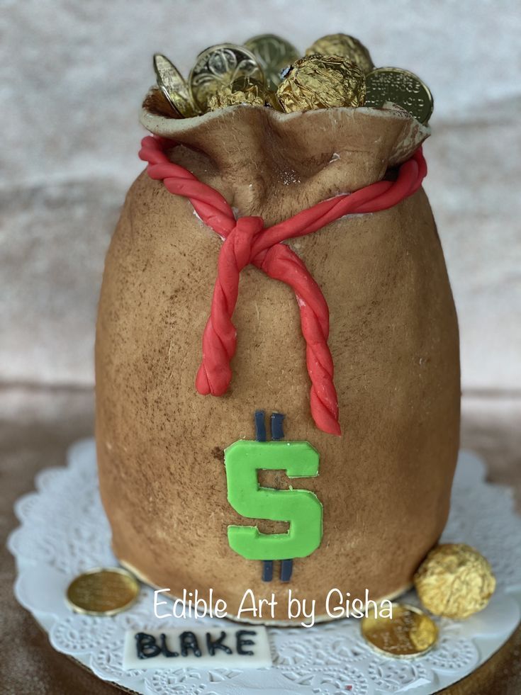 a cake made to look like a sack of gold coins with the letter g on it