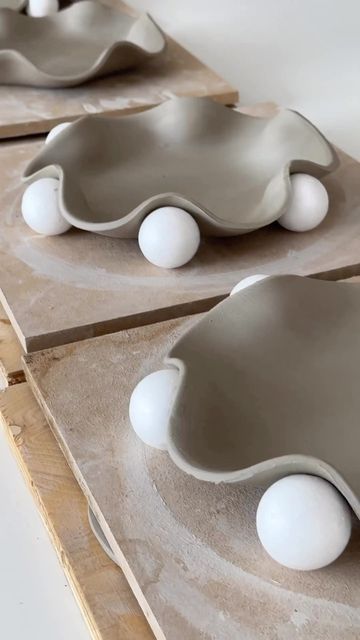 three gray and white bowls sitting on top of each other in front of a wooden board