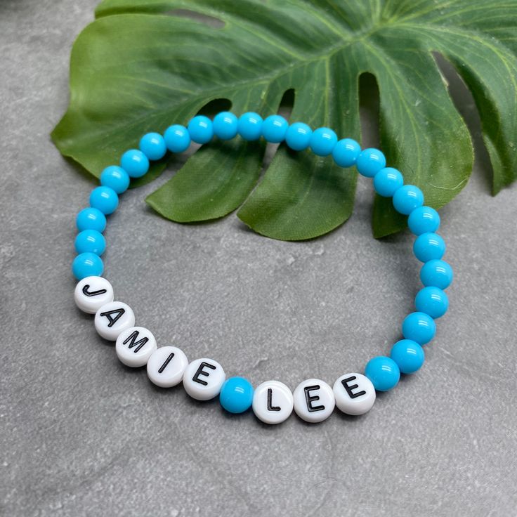 A super cute light blue acrylic name bracelet with your choice of wording and size! Personalise it with your name, your child's name, an inspirational word, your team name, a pet name, a nickname, or anything else you can think of eg Best Nanny, Bridesmaid, or an anniversary date or birth date.The custom made bracelet has 6mm acrylic beads and flat white acrylic letter beads, which are 7mm diameter. It is thread on strong elastic and will stretch a little bit so you can roll it onto your wrist g Adjustable Blue Beaded Bracelets With Custom Name, Adjustable Blue Jewelry With Custom Name, Casual Hypoallergenic Name Bracelet For Birthdays, Blue Jewelry With Custom Name, Custom Name Blue Beaded Bracelets For Friendship, Custom Name Blue Beaded Bracelet For Friendship, Personalized Casual Name Bracelet With Round Beads, Blue Round Bead Stretch Bracelet For Birthday, Blue Casual Name Bracelet For Friendship