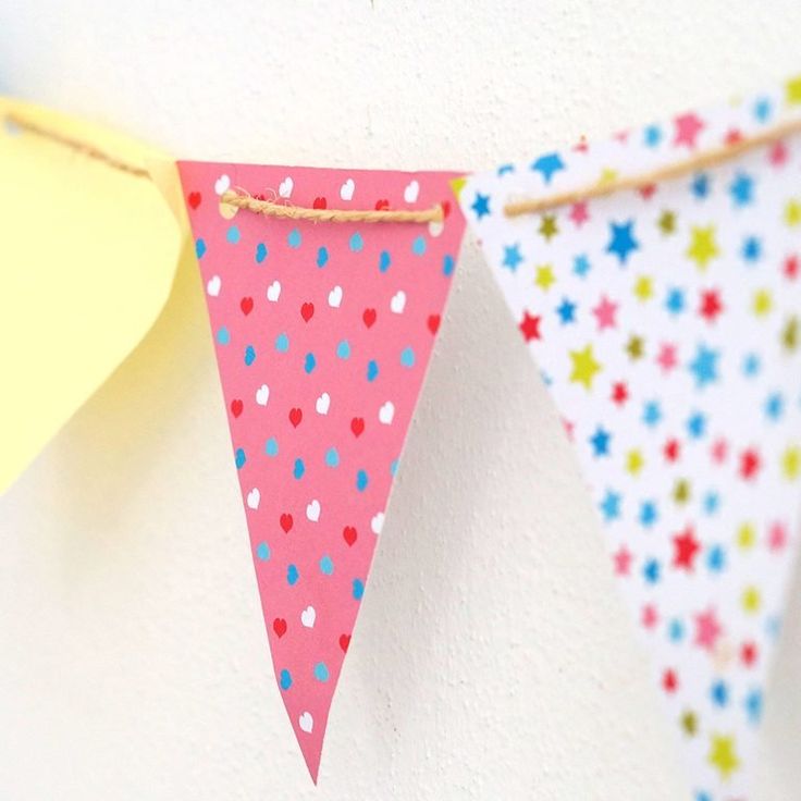 colorful paper buntings hanging on the wall with confetti sprinkles