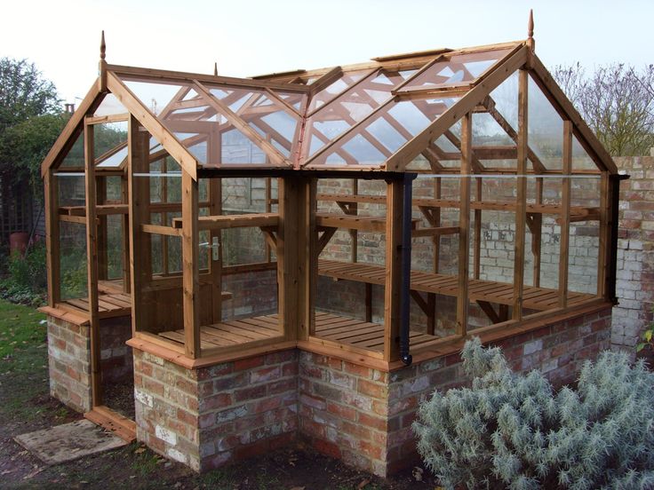 a wooden greenhouse built into the side of a brick building