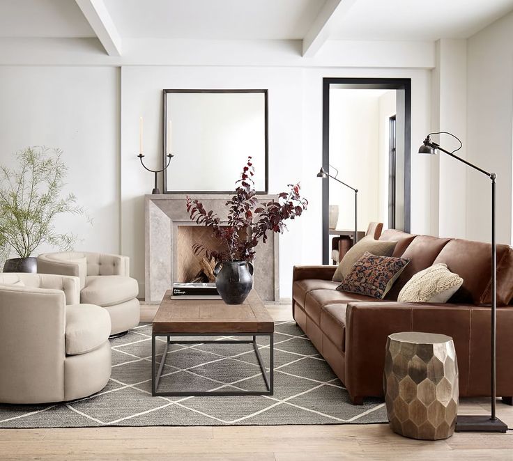 a living room with couches, chairs and a fire place in the center area