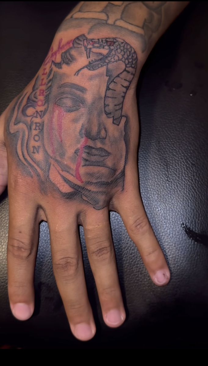 a man's hand with a tattoo on it