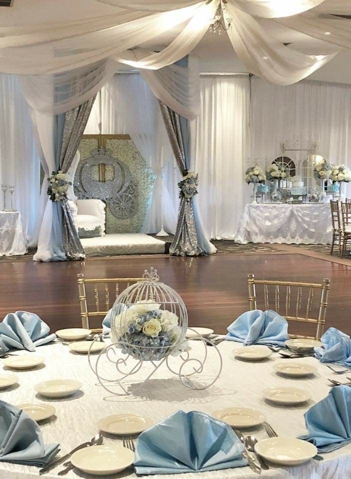 a banquet hall set up with blue and white table cloths, place settings and centerpieces