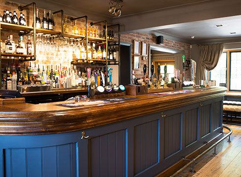 a bar with many bottles and glasses on it