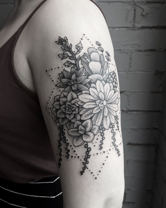 a black and white photo of a woman's arm with flowers on it