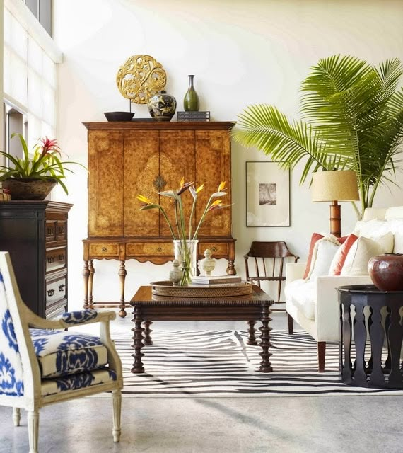 a living room filled with furniture and lots of plants on top of the coffee table