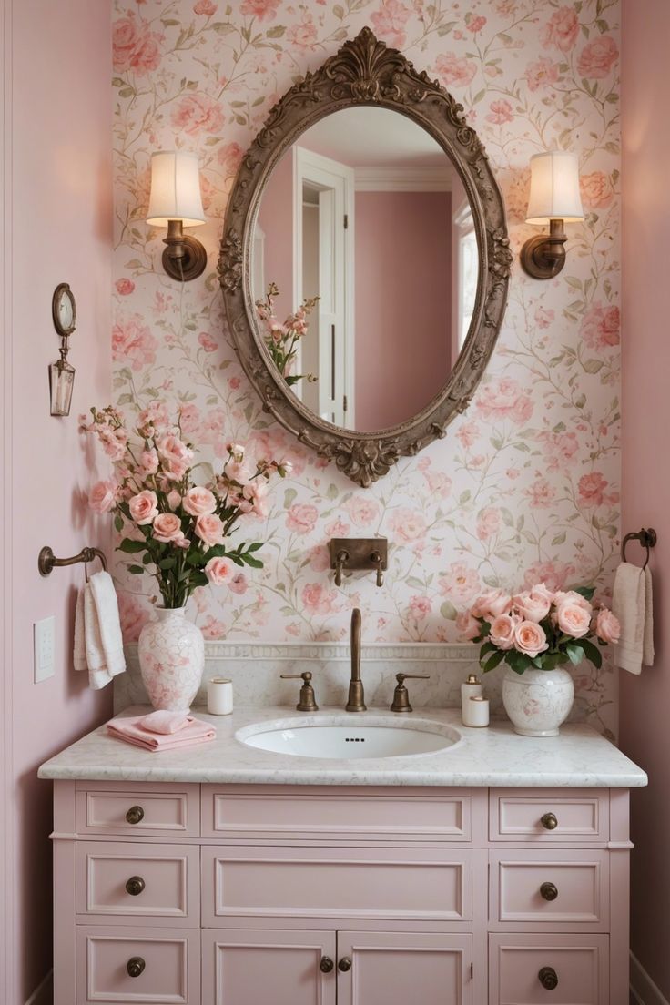 a bathroom with pink and white flowers on the wall, a round mirror above the sink