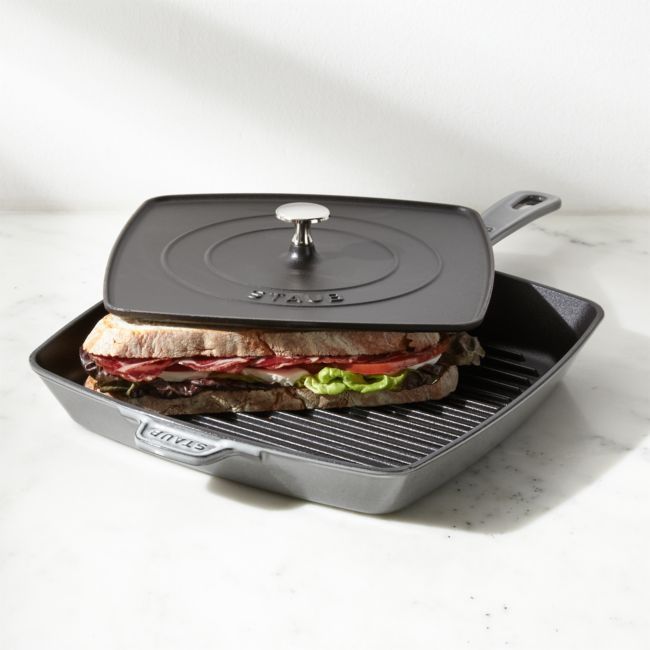 a grill with a sandwich on it sitting in front of a white wall and floor