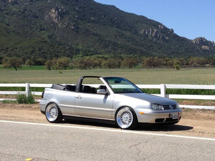 a silver convertible car parked on the side of a road