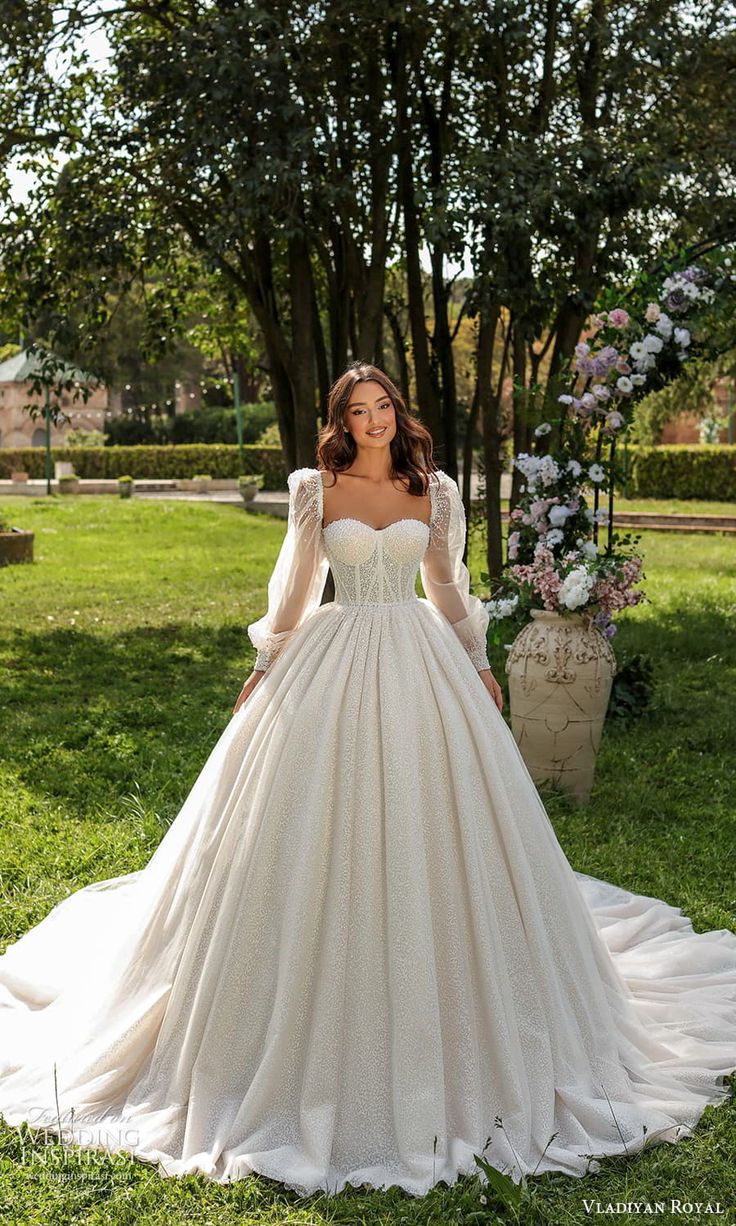 a woman in a wedding dress standing on the grass