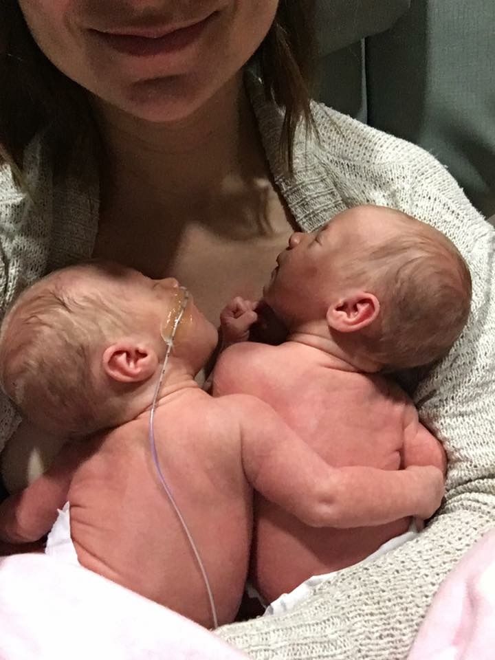 a woman holding two babies in her arms