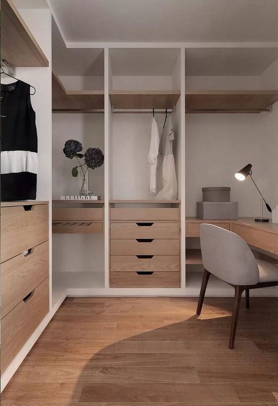 an empty dressing room with white walls and wooden flooring