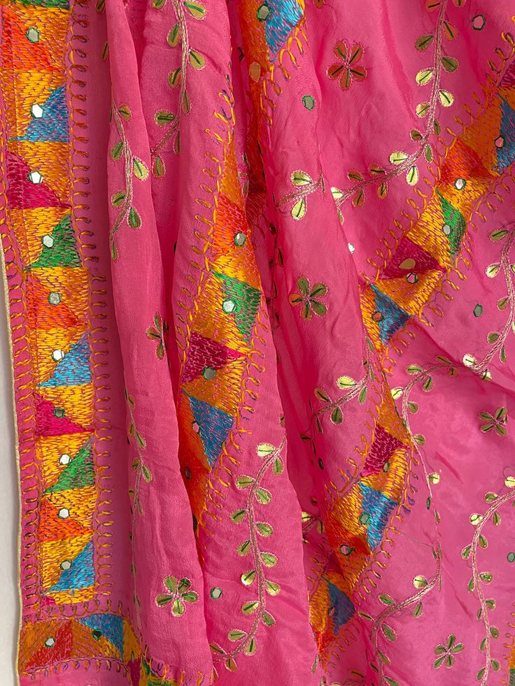 This elegant traditional Dark Pink Bridal Phulkari Dupatta is expertly crafted from Chinon Silk, with Gotta Patti and phulkari hand embroidery all over. The perfect choice for weddings, sangeet, jaago, and chunni ceremonies. Material: Semi silk chinonWork: Silk thread phulkari handwork, needlework, gotta patti workPattern: FloralSize: Full Size 2.5 metersDispatched in 1-3 business days Product Note:​ This is a handcrafted product from artisans and producer groups and due to the nature of the pro Pink Semi-stitched Traditional Wear For Festival, Traditional Pink Silk Thread Choli, Pink Silk Dupatta With Dori Work, Traditional Silk Thread Wear For Celebration, Traditional Embroidered Pink Choli, Multicolor Silk Thread Traditional Wear For Festivals, Purple Dori Work Dupatta For Festivals, Traditional Purple Dupatta With Dori Work, Multicolor Silk Traditional Wear For Festivals