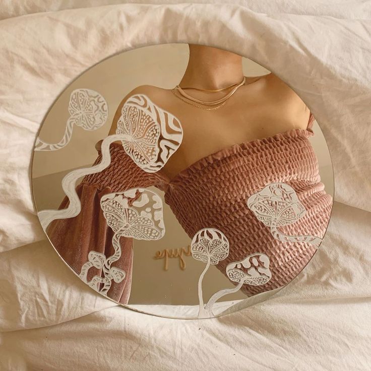 a woman's sweater is reflected in a round mirror