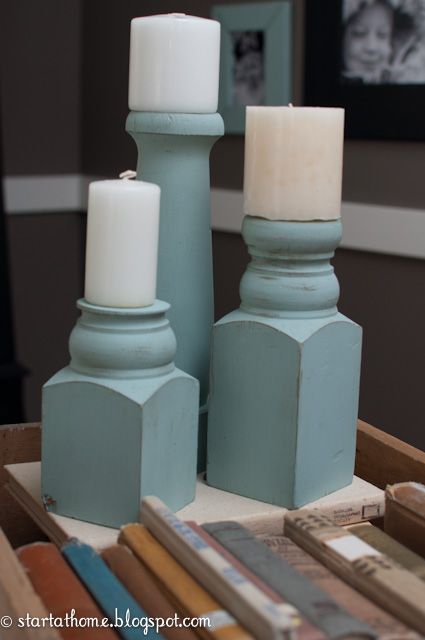 two candles sitting on top of a table next to books