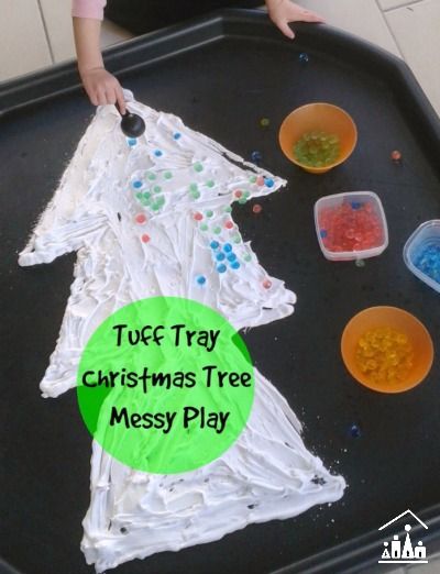 a child is making a christmas tree made out of plastic cups and paper plates on a tray