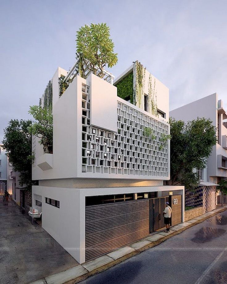 an architecturally designed building on the corner of a street with trees growing out of it