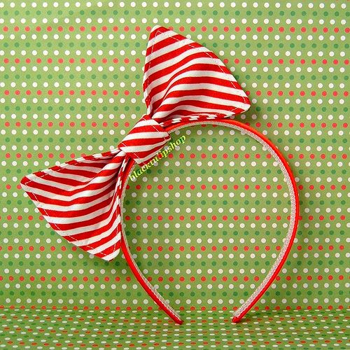 a red and white striped bow on top of a green polka dot tablecloth background