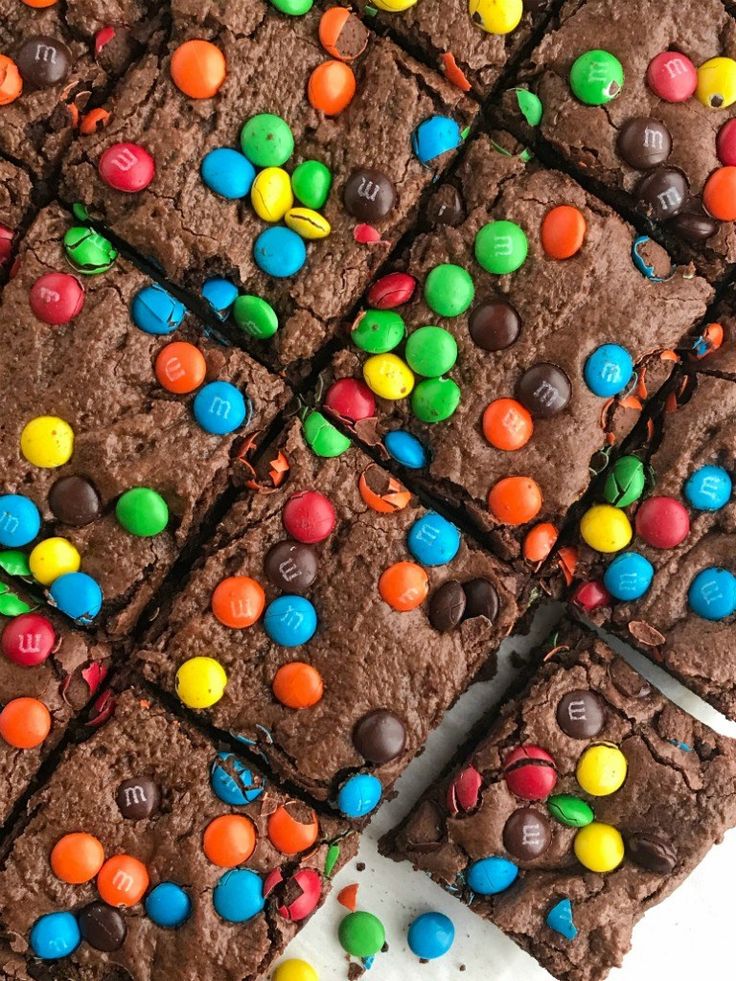 chocolate brownies with m & m candies on top are arranged in square rows