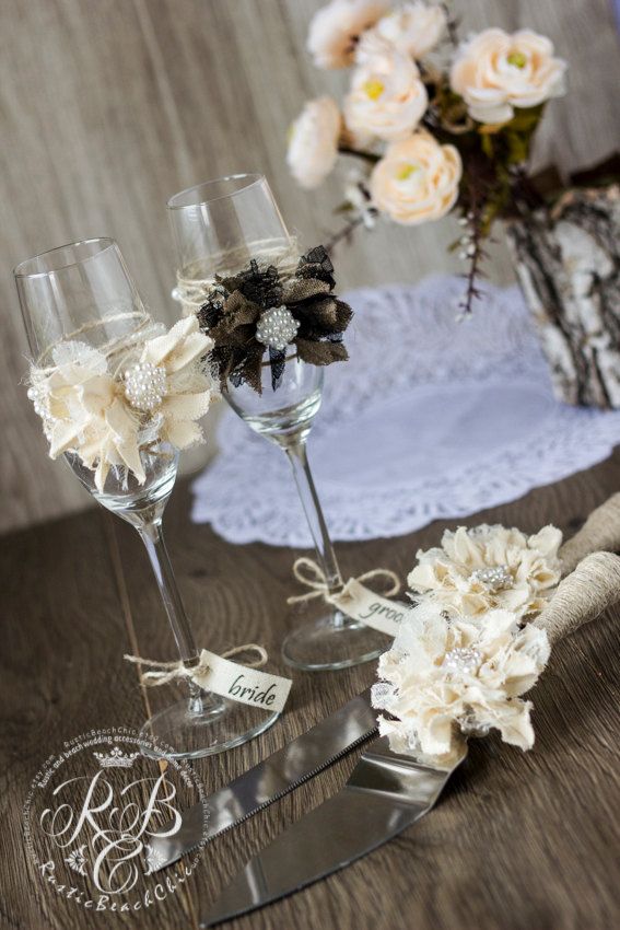 two wine glasses with flowers in them on a table