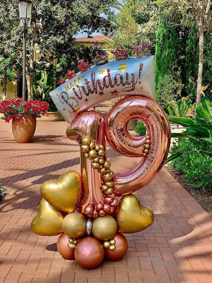 a large balloon shaped like a number with balloons attached to it's face and the words happy birthday written on top