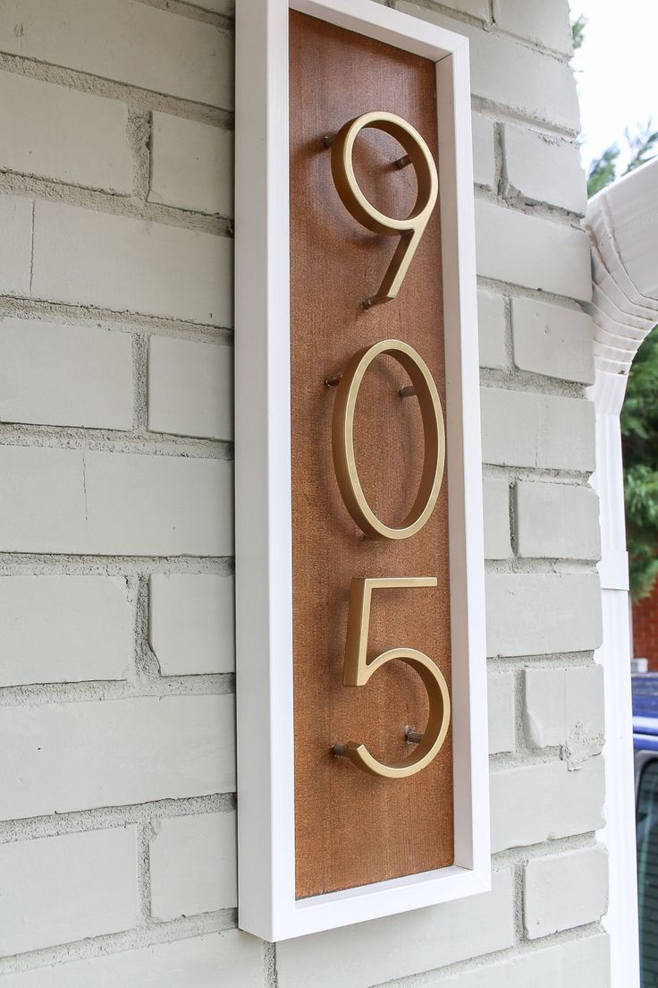 a house number sign mounted to the side of a building