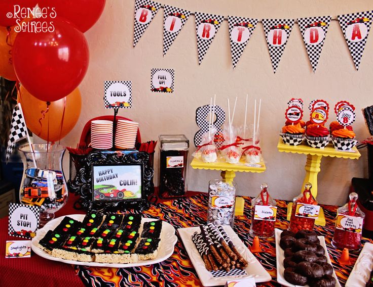 a table topped with lots of desserts and balloons