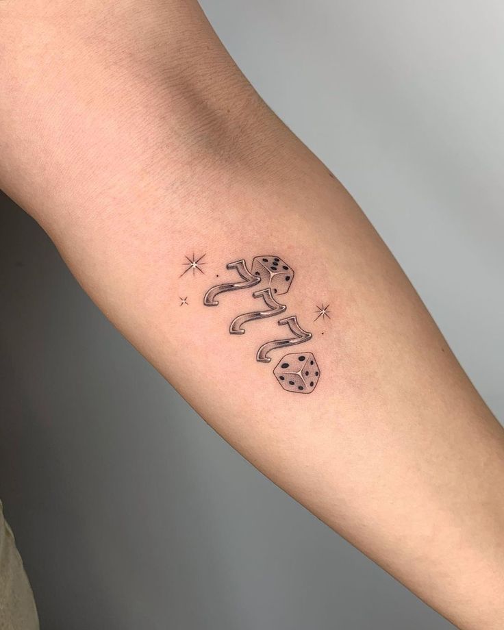 a person's arm with a tattoo on it that has two dogs and stars