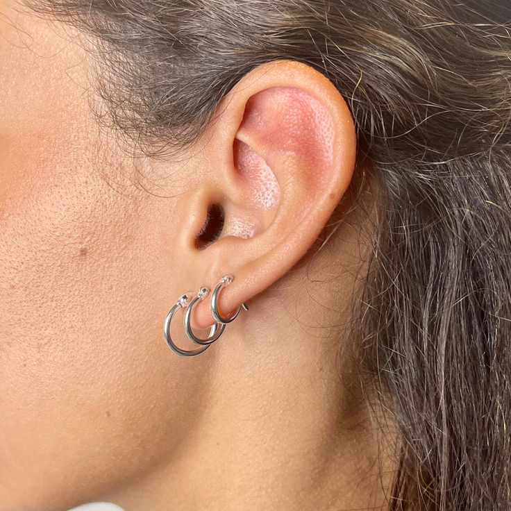 Handmade item Ships from a small business in Connecticut Materials: Sterling silver Location: Cartilage, Earlobe Closure: Snap Top Style: Minimalist .925 sterling silver 1.5 x 10mm, 1.5 x 12mm or 1.5 x 14mm snap top hoop earrings.Hoops sold as a pair.To close, snap top down. Delicate style earring.Three sizes available to choose from, choose hoop size from drop down menu.*Please note due to hygiene reasons and for the safety of our customers and employees, pierced earrings are not returnable.Ple Sterling Silver Piercings For Anniversary, Sterling Silver Huggie Piercings For Anniversary, Sterling Silver Stackable Huggie Earrings As Gift, Stackable Sterling Silver Huggie Earrings As Gift, Sterling Silver Stackable Huggie Earrings For Everyday, Silver Small Hoop Piercings As Gift, Dainty Silver Huggie Earrings, Everyday Stackable Sterling Silver Huggie Earrings, Everyday Sterling Silver Stackable Hoop Earrings