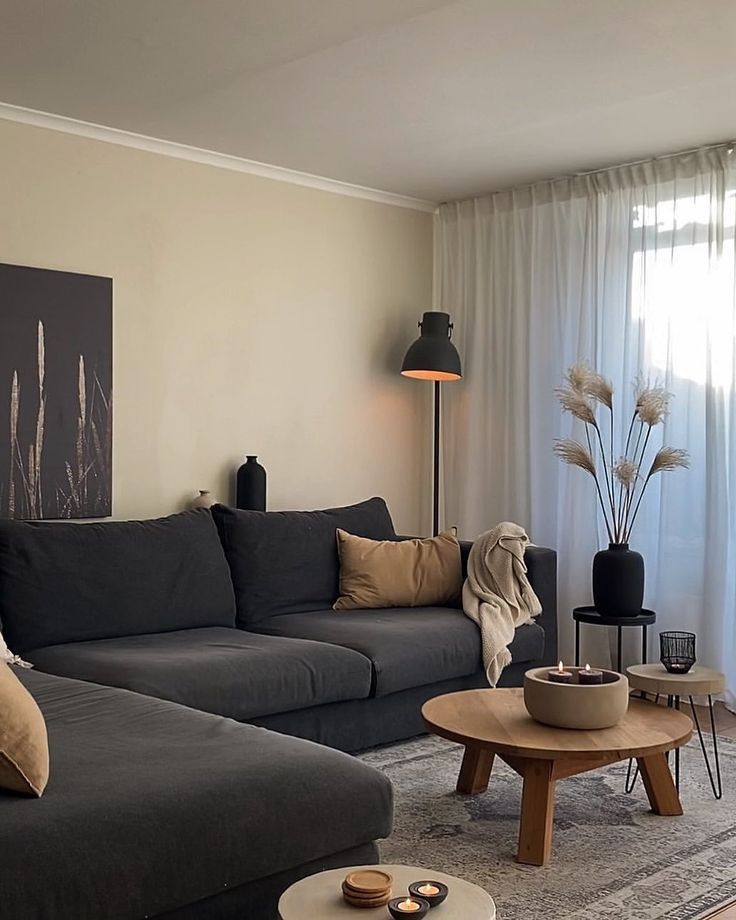 a living room filled with furniture and a large painting on the wall above it's windows