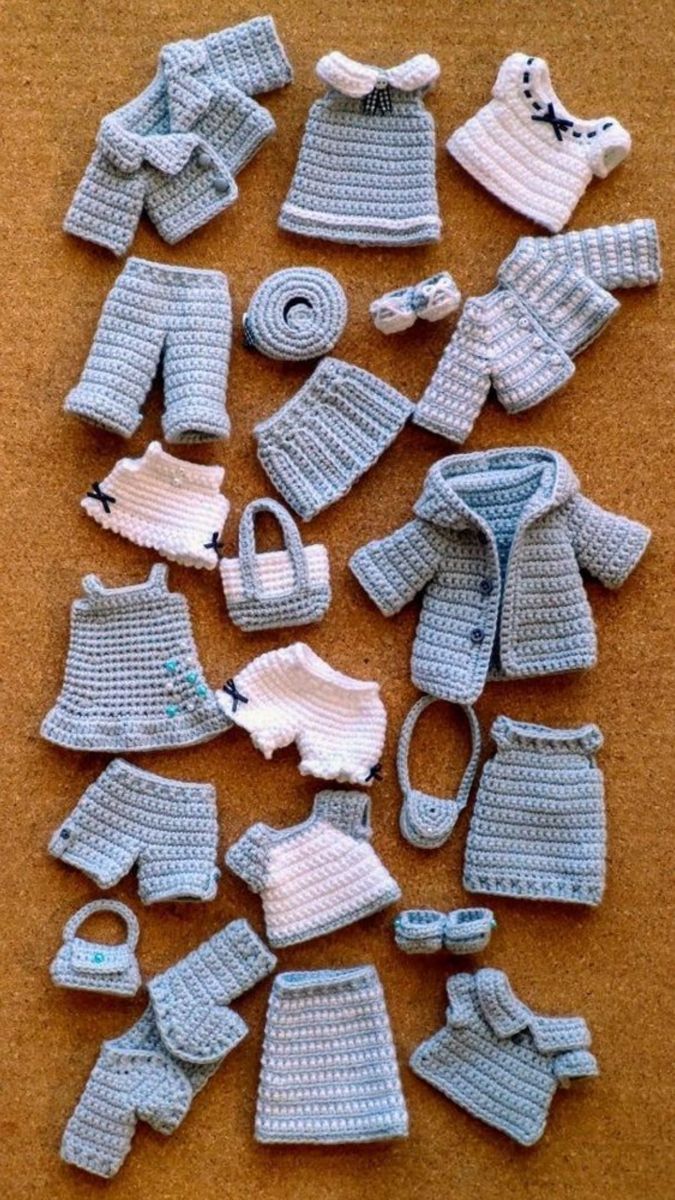 crocheted baby clothes and accessories laid out on the floor