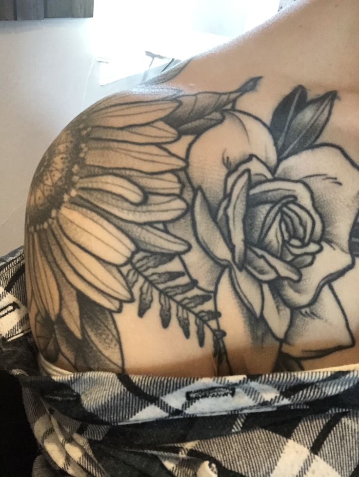 the back of a woman's shoulder with flowers on it