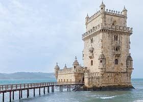 an old tower sitting on top of a pier next to the ocean