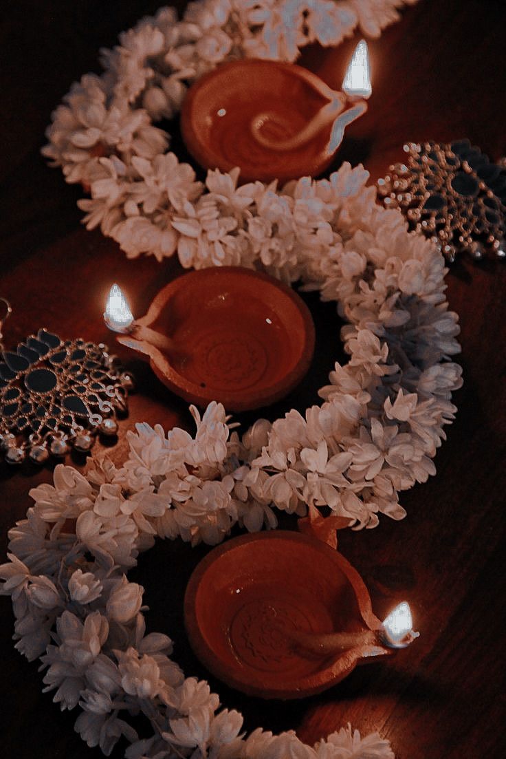 three candles are sitting on top of some flowers