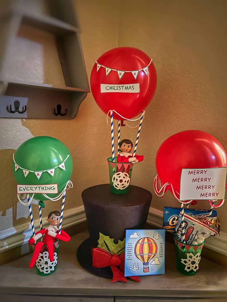 some balloons and other items on a shelf in a room with a sign that says merry christmas